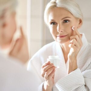 Mature woman applying skincare to her face
