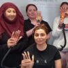 Smiling nail students showing their practice hands