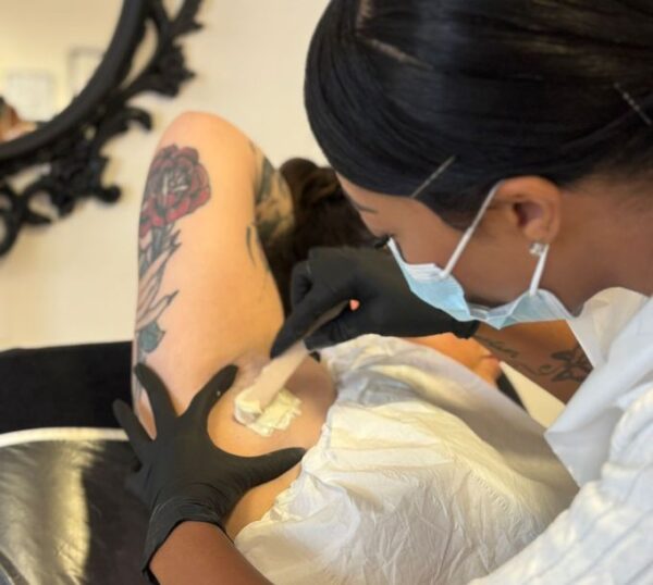 Student waxing a client's arm during training
