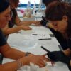 Students practising manicures at training desks
