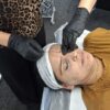 Student tinting a model's brows
