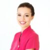 Smiling beauty therapist in a pink tunic