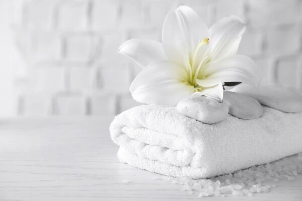 White lily on folded spa towels