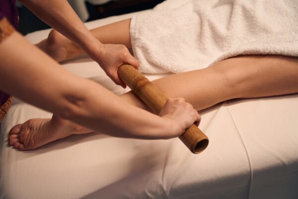 Bamboo massage being given to a client's legs