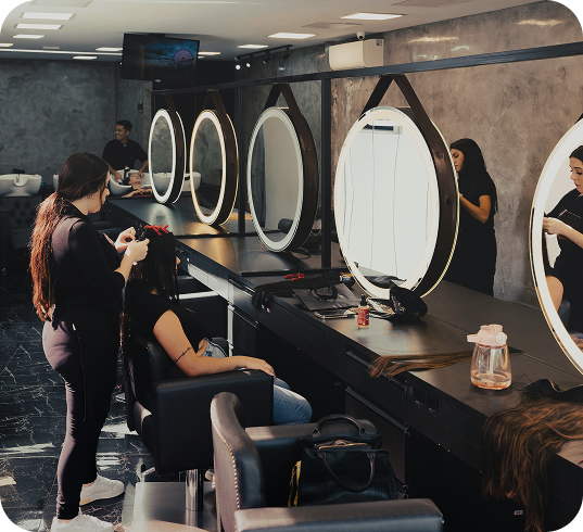 Students at make-up stations in a Beauty Academy training room