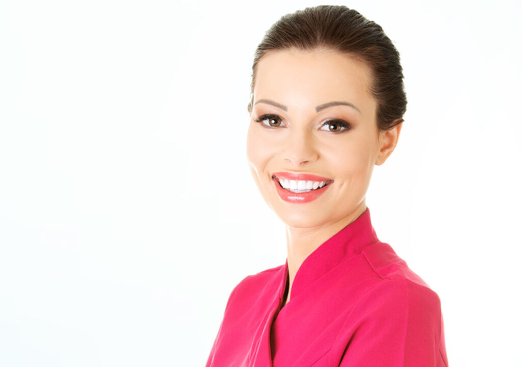 Smiling beauty therapist in a pink tunic