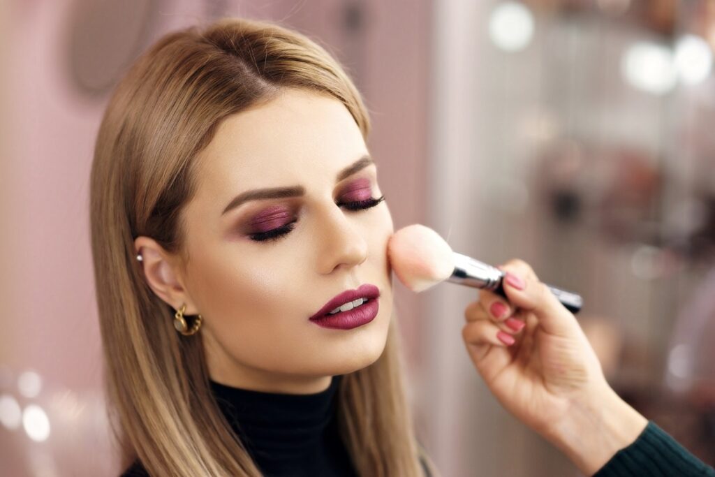 Make-up artist applying blusher to a model